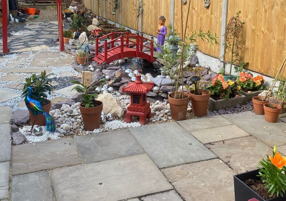 Natural stone patio and pond in a Bramhope Japanese garden