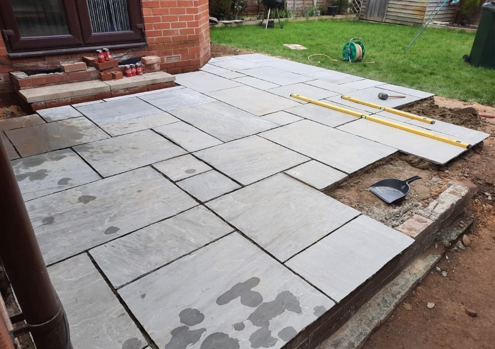 Slate paving being laid in Oakwood with levels resting on the slabs