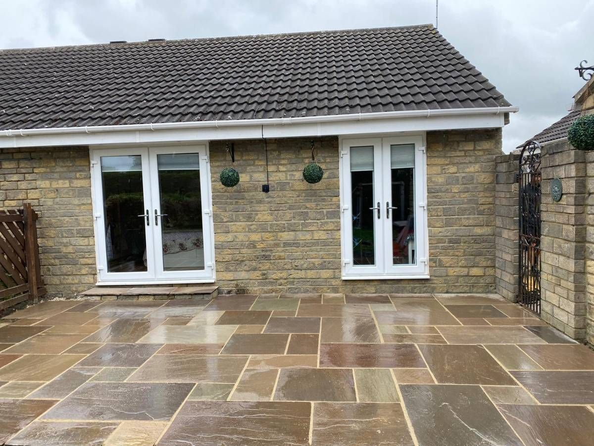 Raj green Indian stone patio across the back of a bungalow in Whinmoor