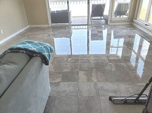 A living room with a couch and a vacuum cleaner on the floor.