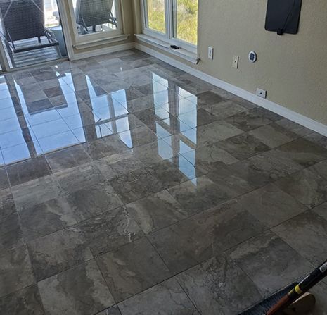 A living room with a tiled floor and a broom.