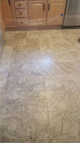 A kitchen with a tile floor and wooden cabinets.