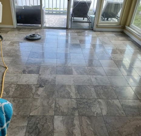 A living room with a tiled floor and a broom.