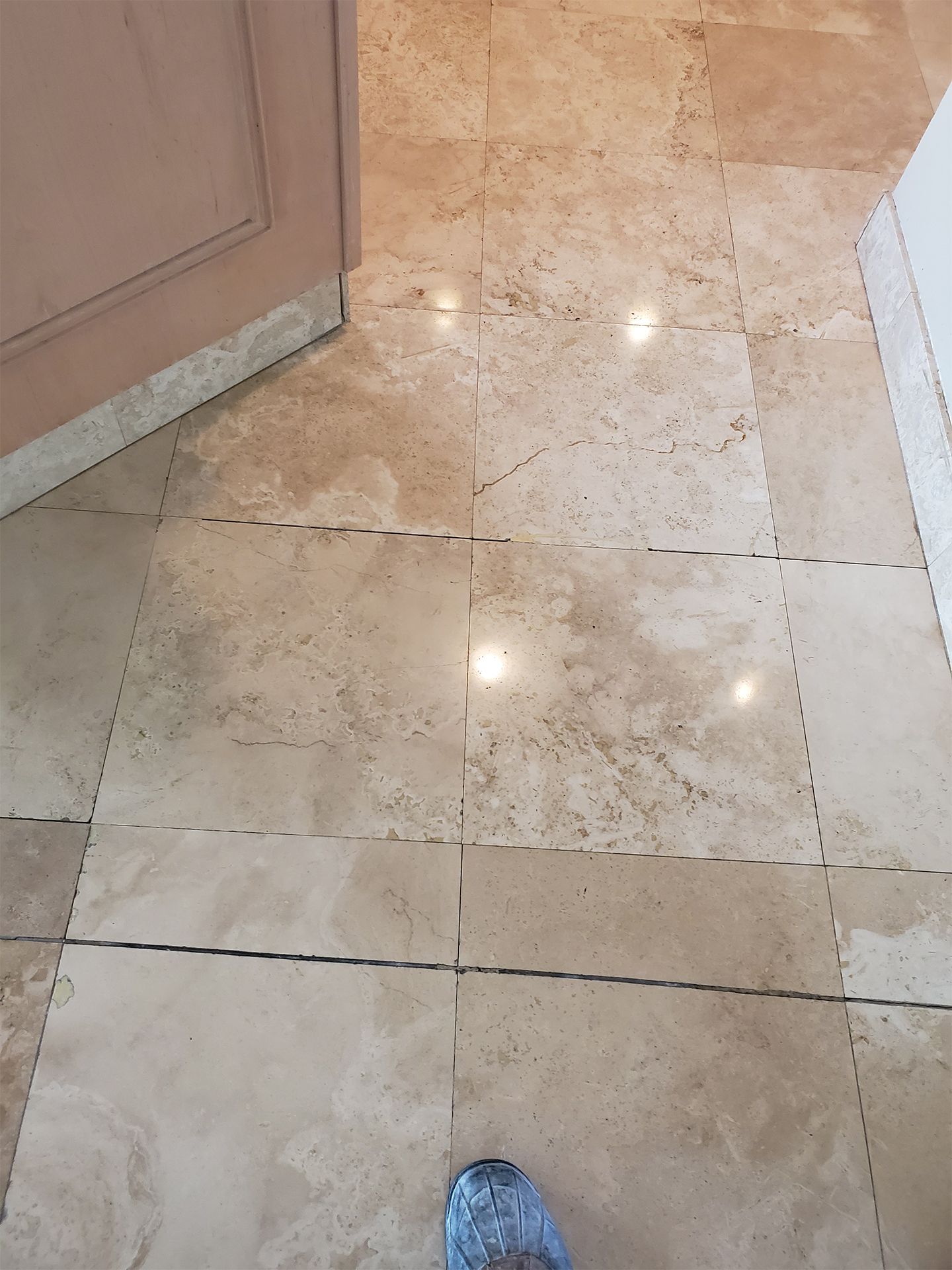 Professional travertine floor polishing in a residential bathroom