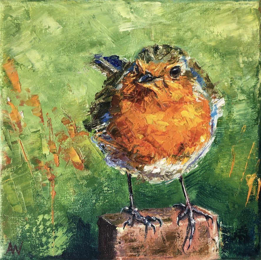European robin with orange breast on a brown block; green background.