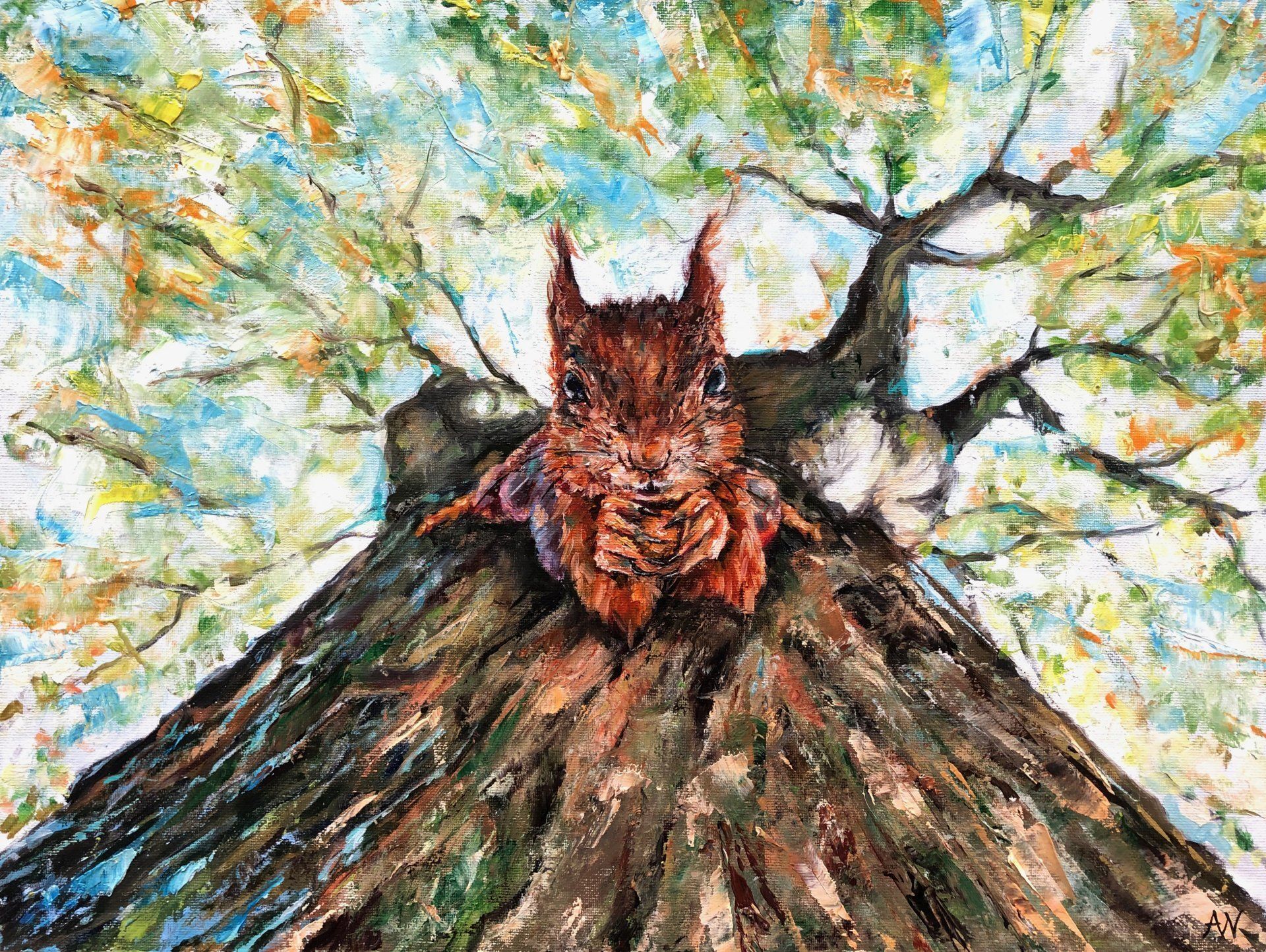 Red squirrel perched on tree trunk, looking forward, with green and blue foliage in the background.