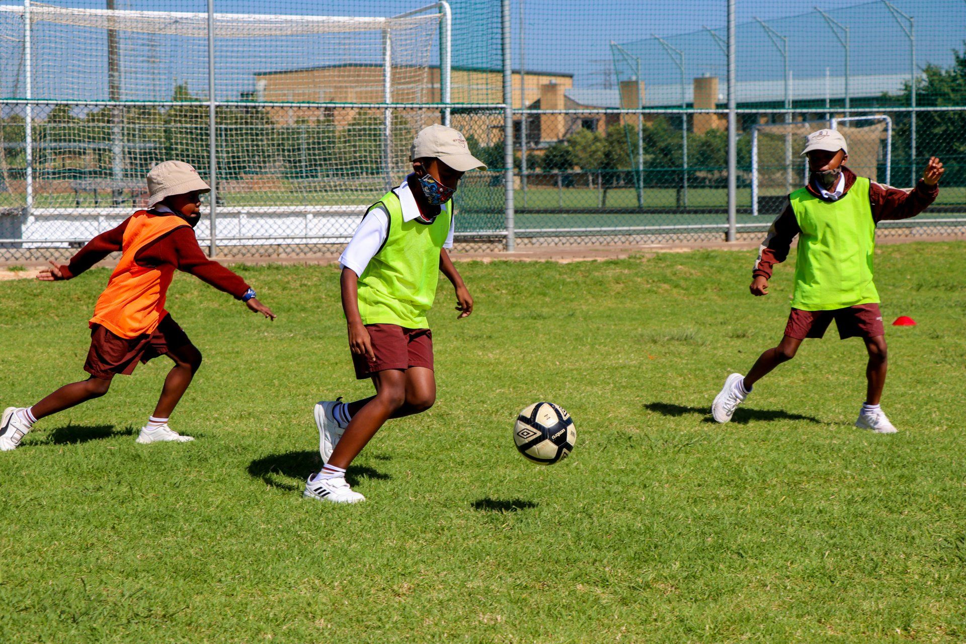 A group of children are playing soccer on a field.