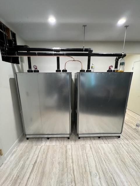 Two metal tanks are sitting next to each other in a room.