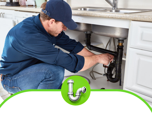 Plumber working under a kitchen sink to fix pipes and drain assembly