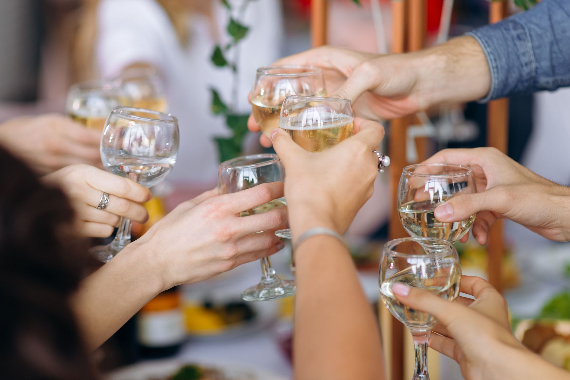 Hands raising champagne glasses in a celebratory toast at a party