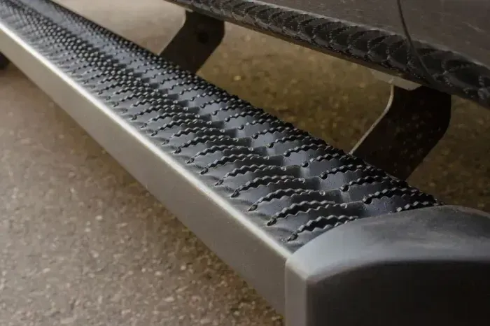 A close up of a side step on a car.