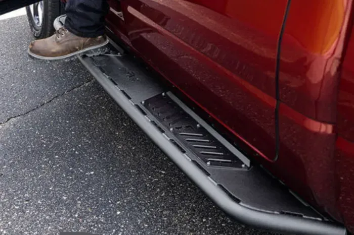 A person is standing on the side of a red truck.