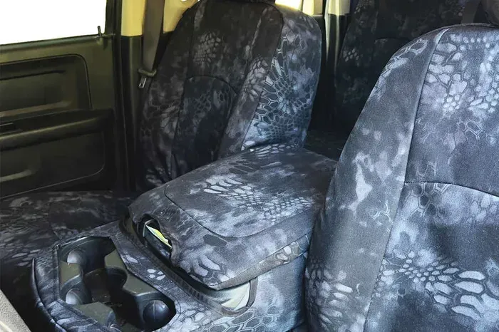 The back seats of a car with camouflage seat covers.
