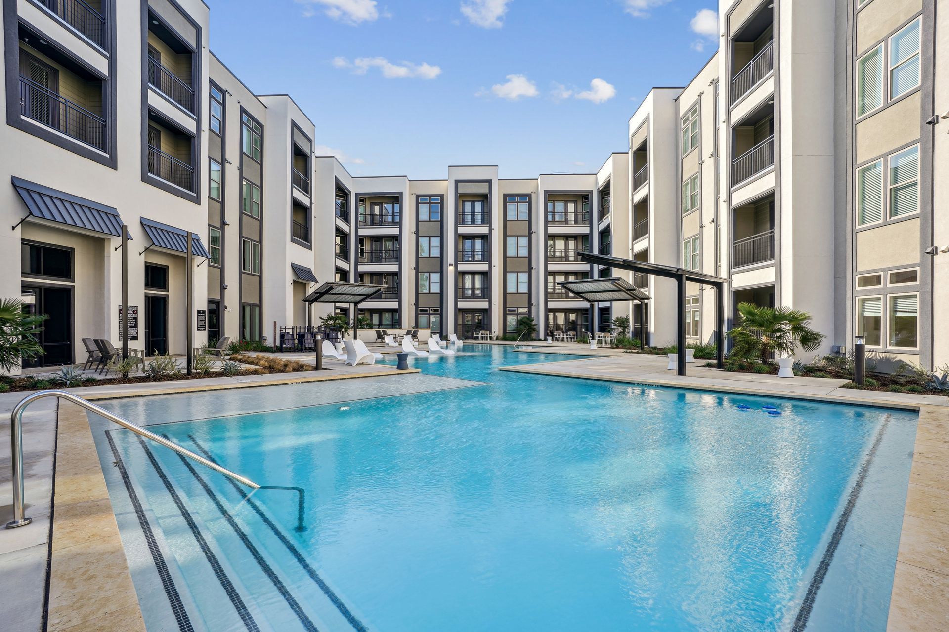 Resort-style outdoor pool surrounded by modern apartment buildings