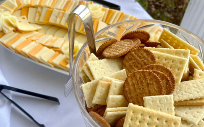 Platters of assorted crackers and cheese slices on a buffet table