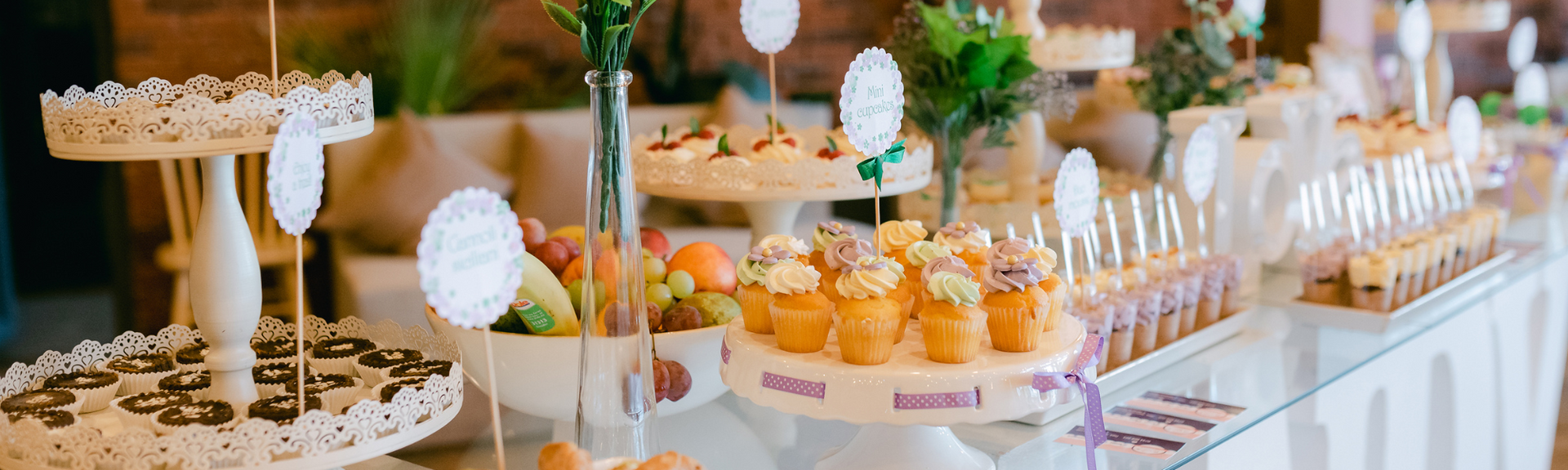 Dessert buffet with cupcakes, pastries, and fruit tarts on a decorated table
