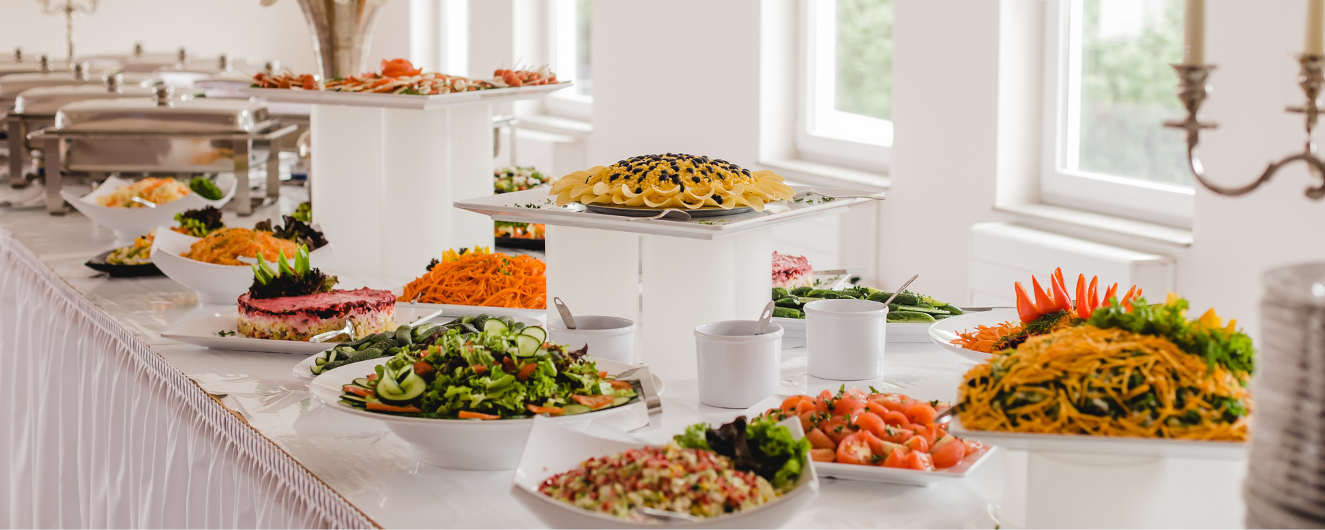 Buffet table with assorted colorful dishes arranged in a bright dining room