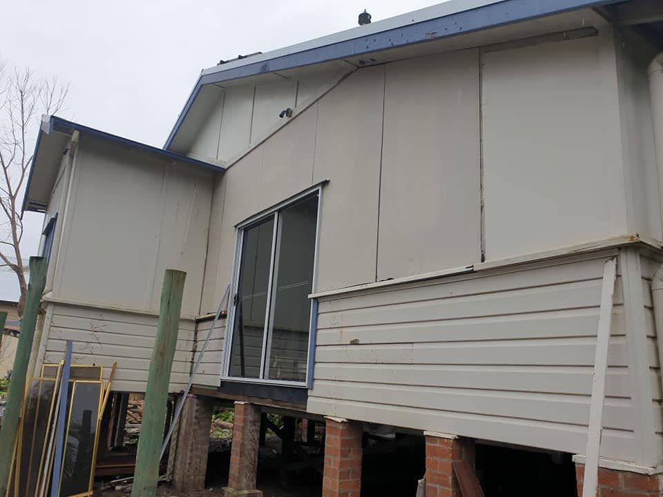 A White House With A Sliding Glass Door Is Being Remodeled — McCarthys Property Services in Woolgoolga, NSW
