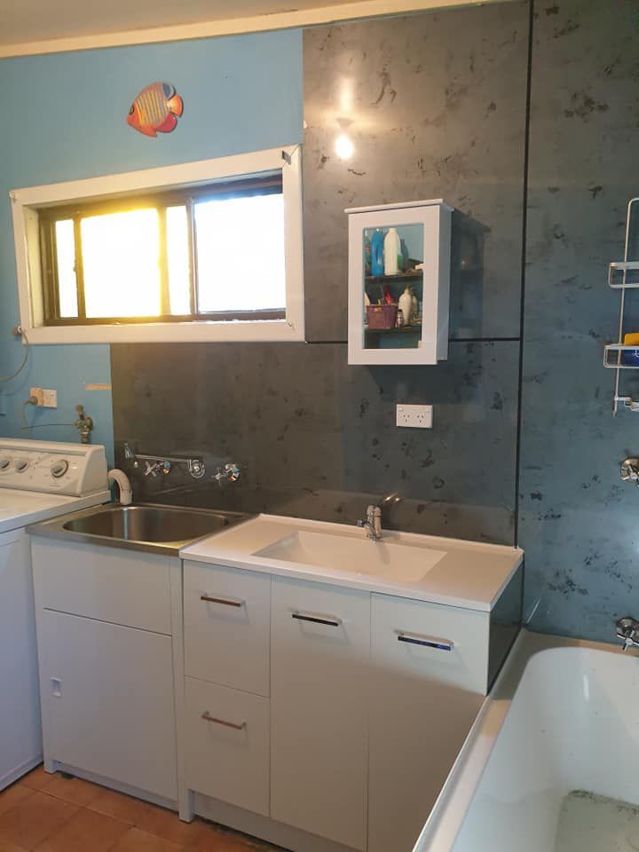 A Laundry Room With A Sink , Washer And Dryer — McCarthys Property Services in Glenugie, NSW