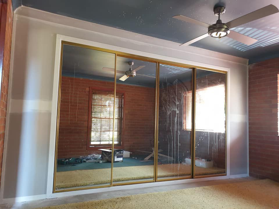A New Room With A Ceiling Fan And Sliding Glass Doors — McCarthys Property Services in Woolgoolga, NSW