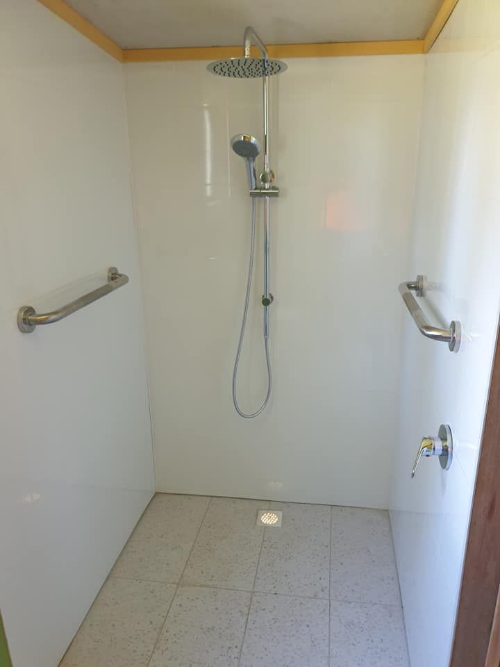 A Shower With A Hand Rail And A Shower Head — McCarthys Property Services in Glenugie, NSW