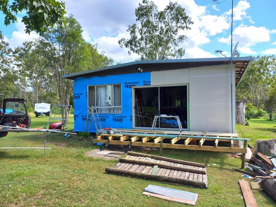A Small House Is Being Repair In The Middle Of A Grassy Field — McCarthys Property Services in Glenugie, NSW
