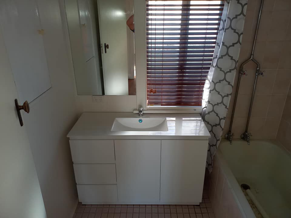 A Bathroom With A Sink A Mirror And A Bathtub — McCarthys Property Services in Woolgoolga, NSW