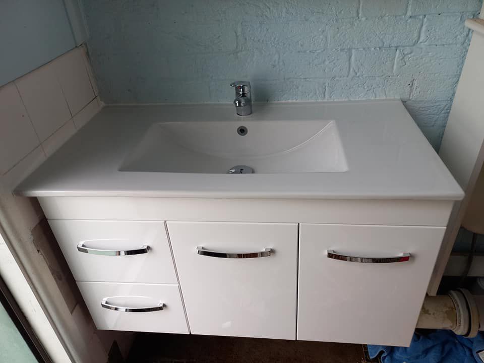 A Bathroom Vanity With A Sink And A Toilet After Renovation — McCarthys Property Services in Maclean, NSW