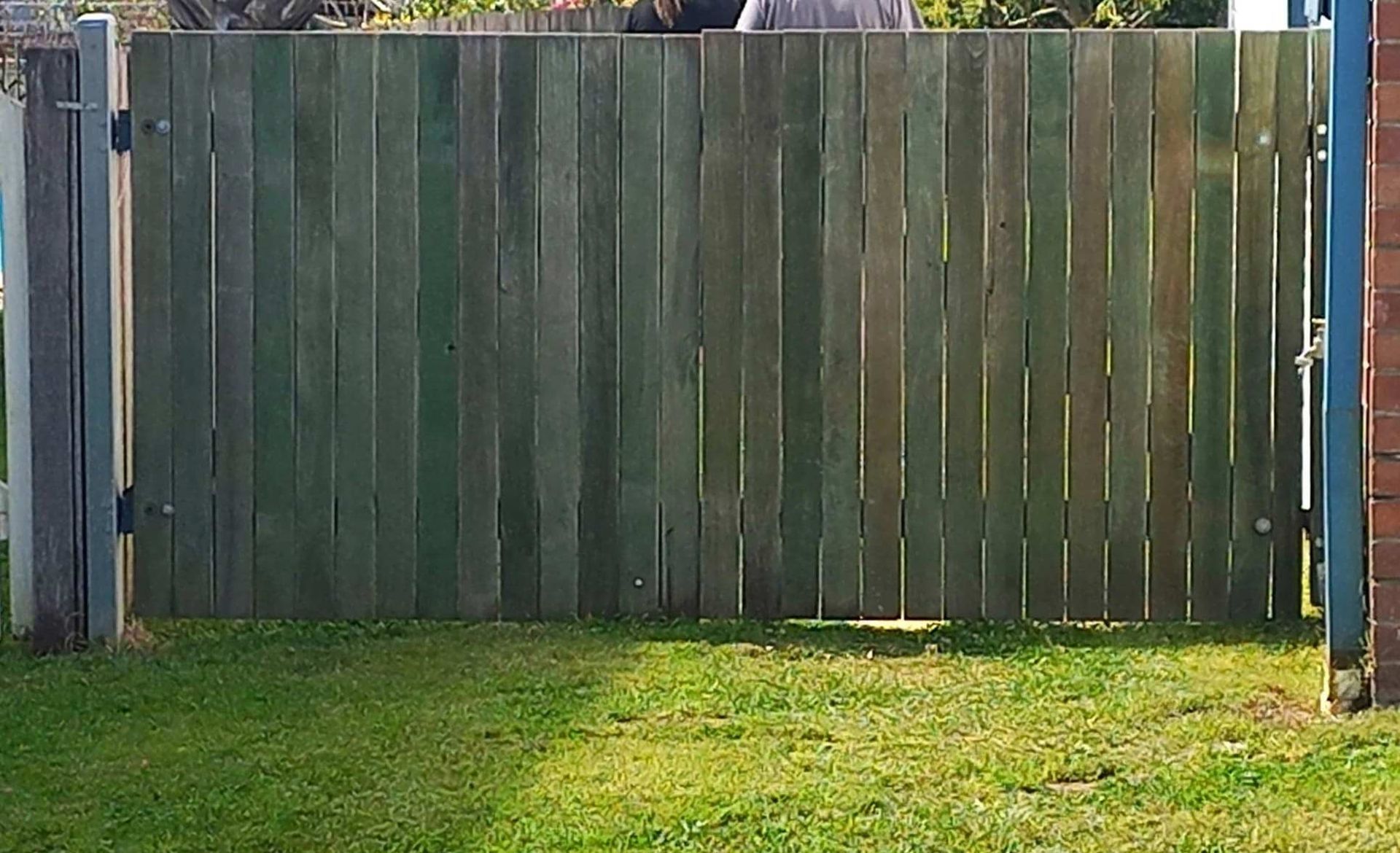 Wooden Fence In The Middle Of A Lush Green Yard — McCarthys Property Services in Yamba, NSW
