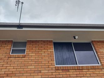 A Brick Building With Two Windows And An Antenna On Top Of It — McCarthys Property Services in Glenugie, NSW