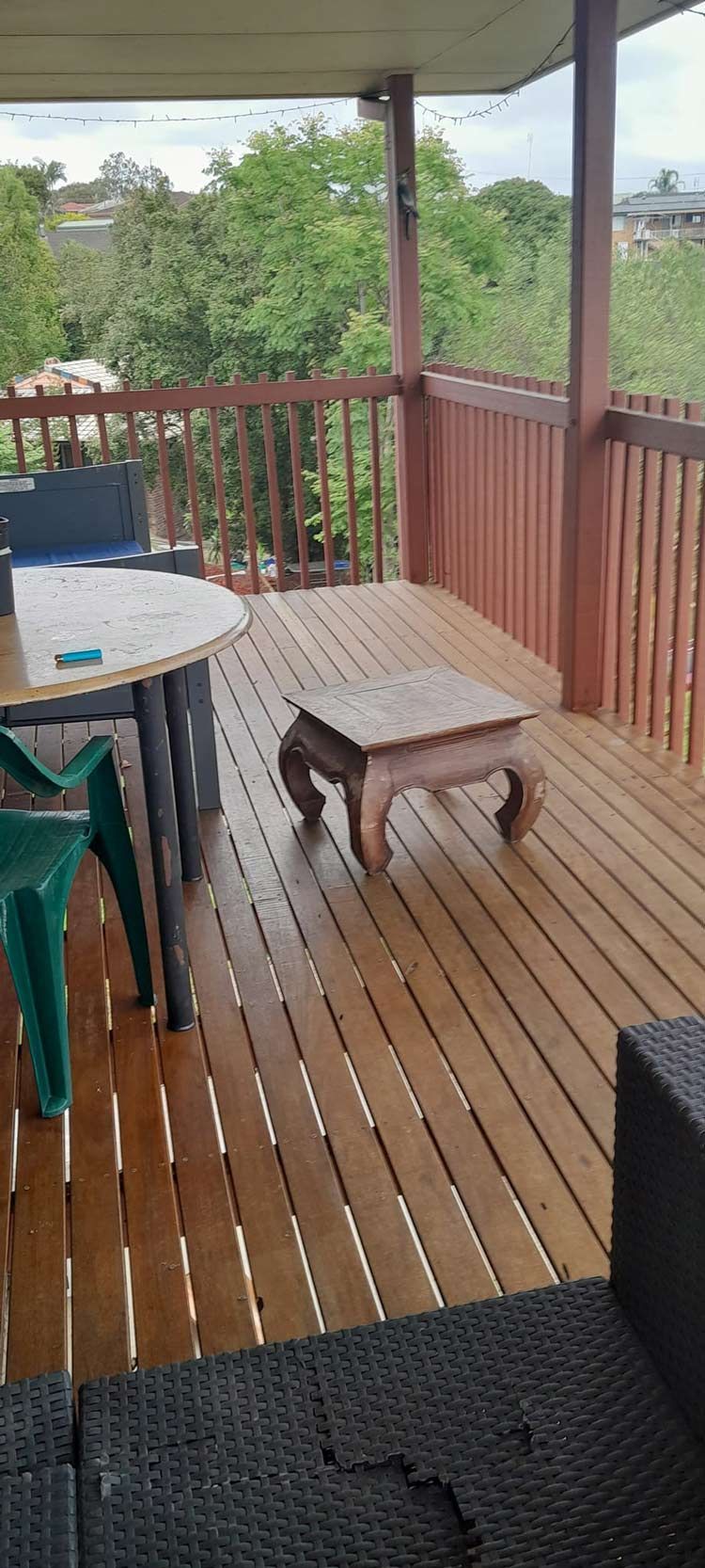 A Wooden Deck With A Table And Chairs On It — McCarthys Property Services in Grafton, NSW
