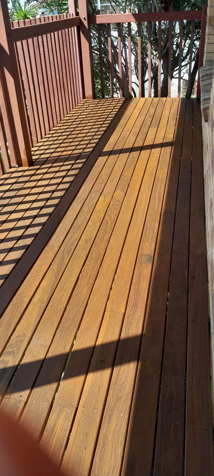 A Wooden Deck With A Bench On It And Trees In The Background — McCarthys Property Services in Grafton, NSW