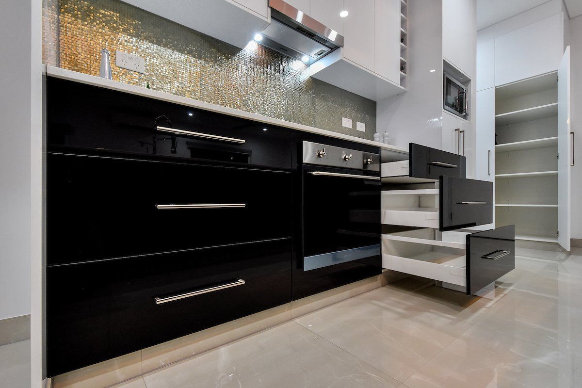 A kitchen with black cabinets and white drawers.