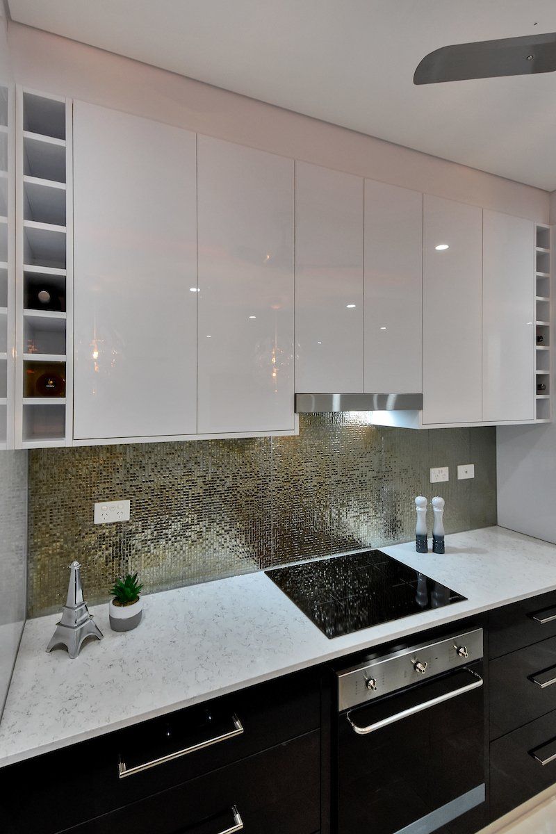 A kitchen with a stove top oven and a ceiling fan
