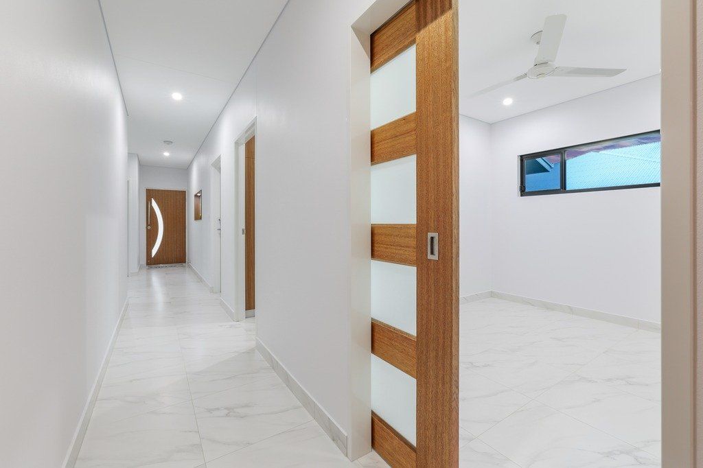 A long hallway with a sliding glass door and a ceiling fan.