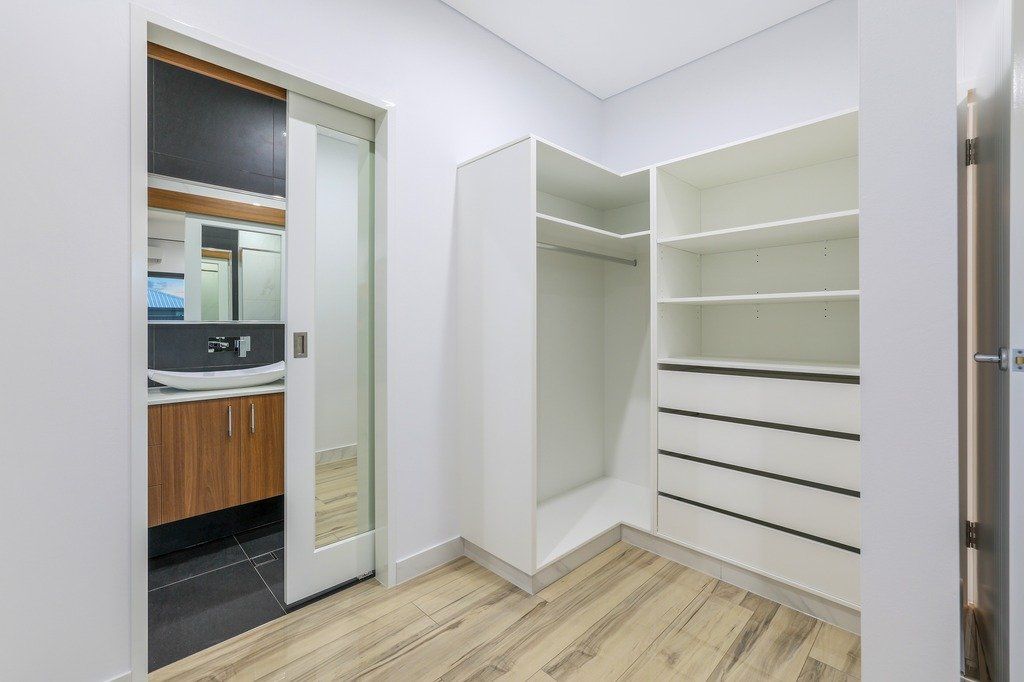 A walk in closet with sliding glass doors leading to a bathroom.