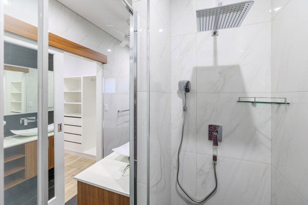 A bathroom with a walk in shower and a sink.