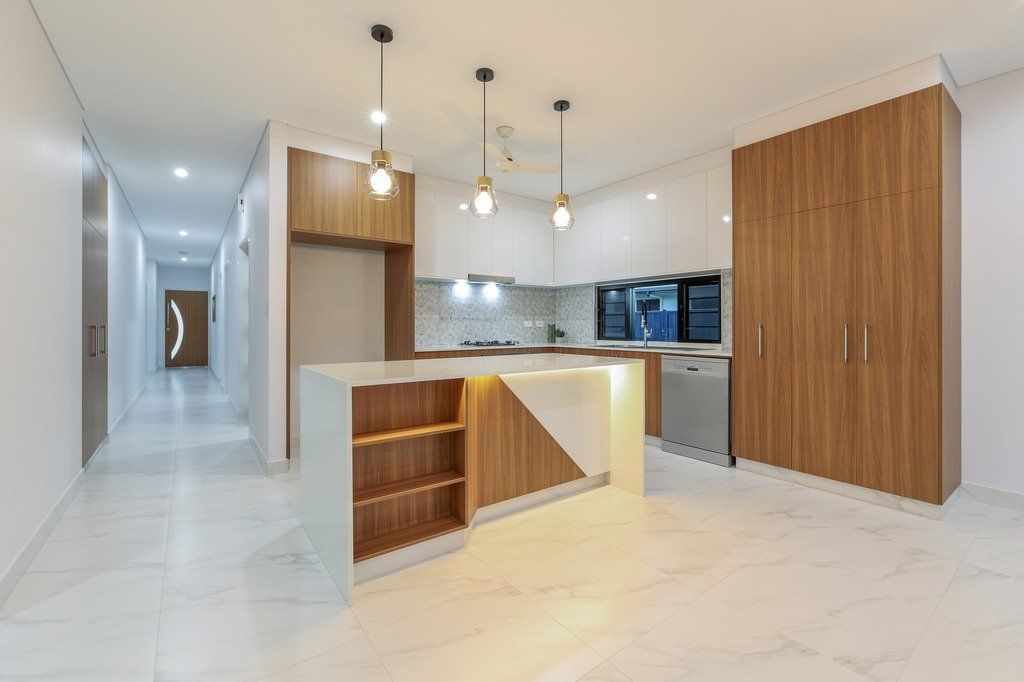 An empty kitchen with a large island in the middle of the room.
