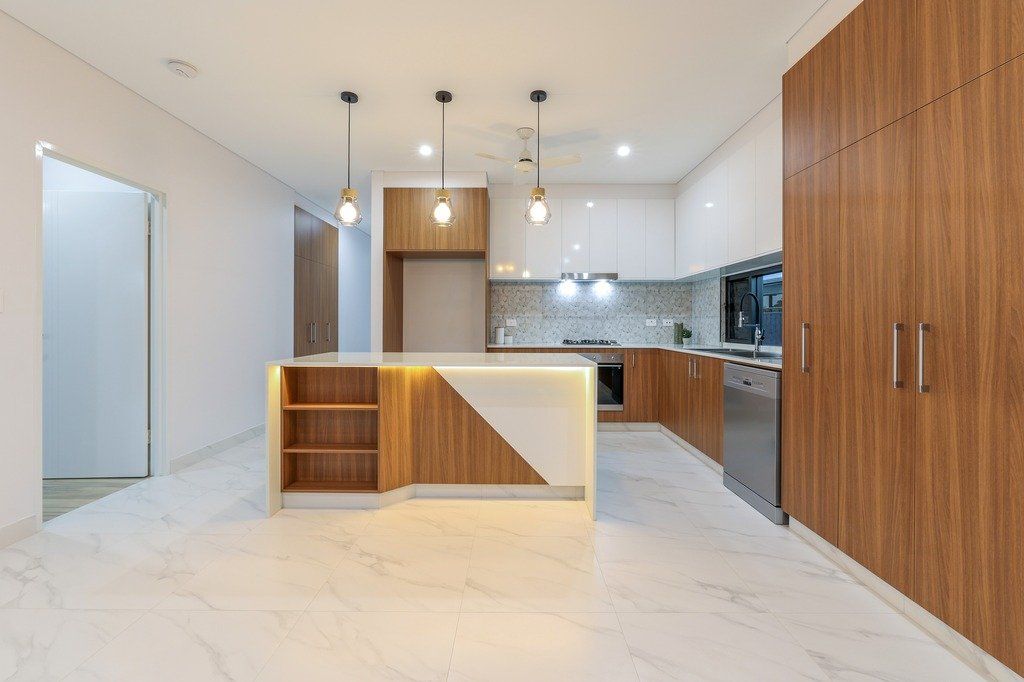 An empty kitchen with wooden cabinets and a large island.