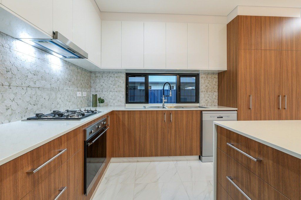 A kitchen with wooden cabinets and white counter tops