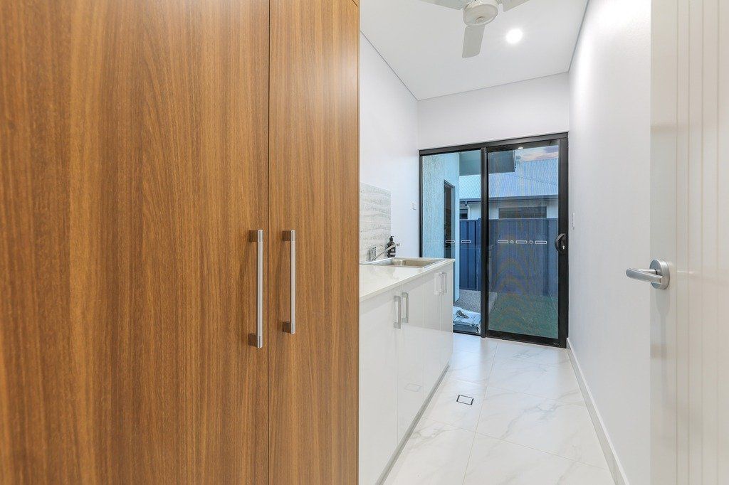 A laundry room with sliding glass doors and a ceiling fan.