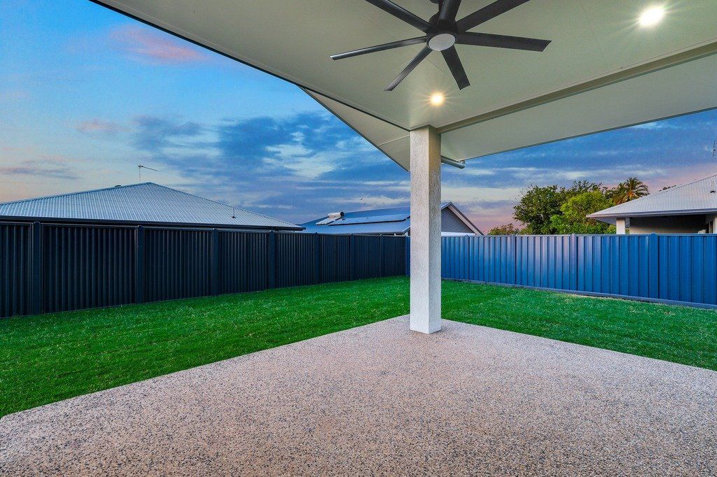 There is a ceiling fan in the backyard of a house.