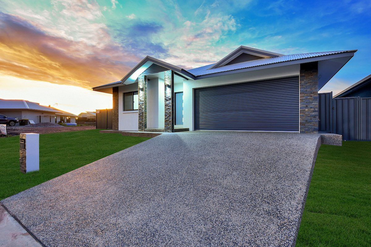 A house with a garage and a driveway in front of it.