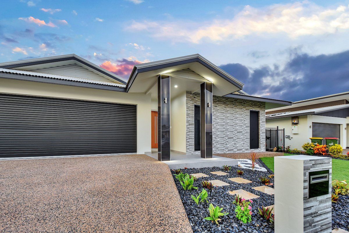 A large house with a large driveway and a large garage.