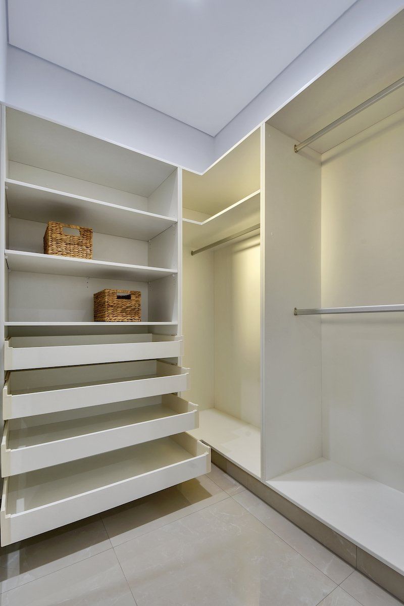 A walk in closet with lots of shelves and drawers.