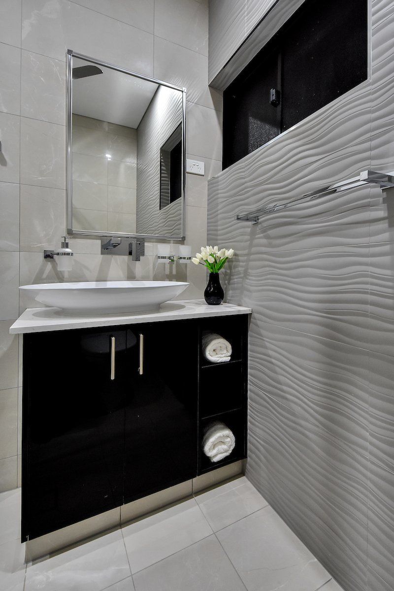 A bathroom with a sink , mirror , and towels.