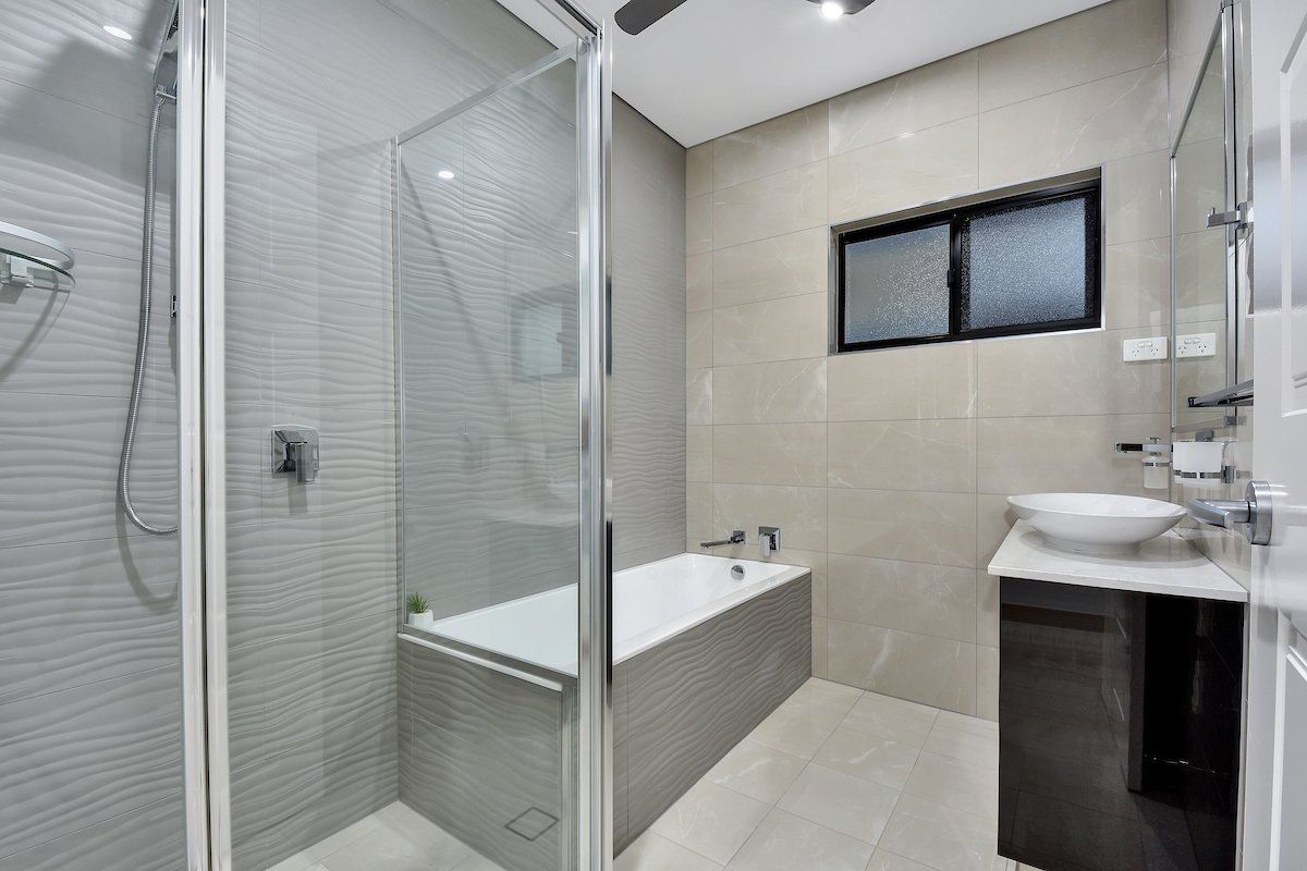 A bathroom with a bathtub , sink and shower.
