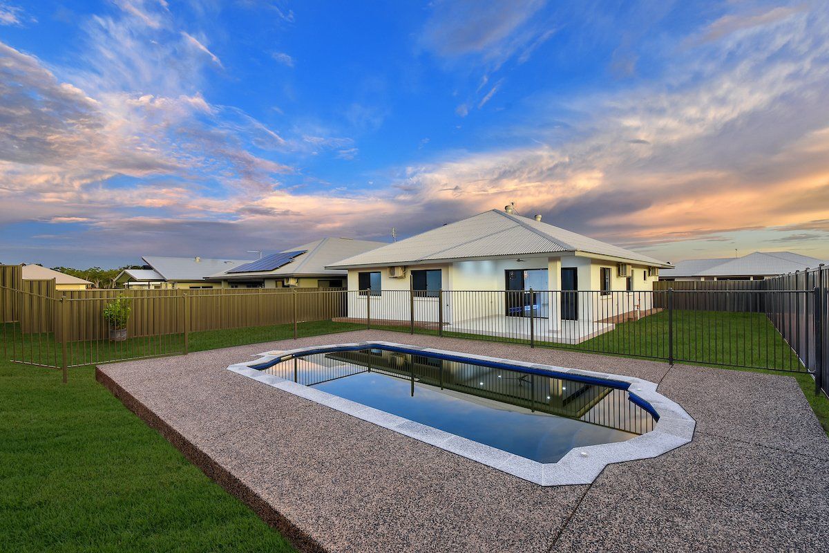 There is a swimming pool in the backyard of a house.