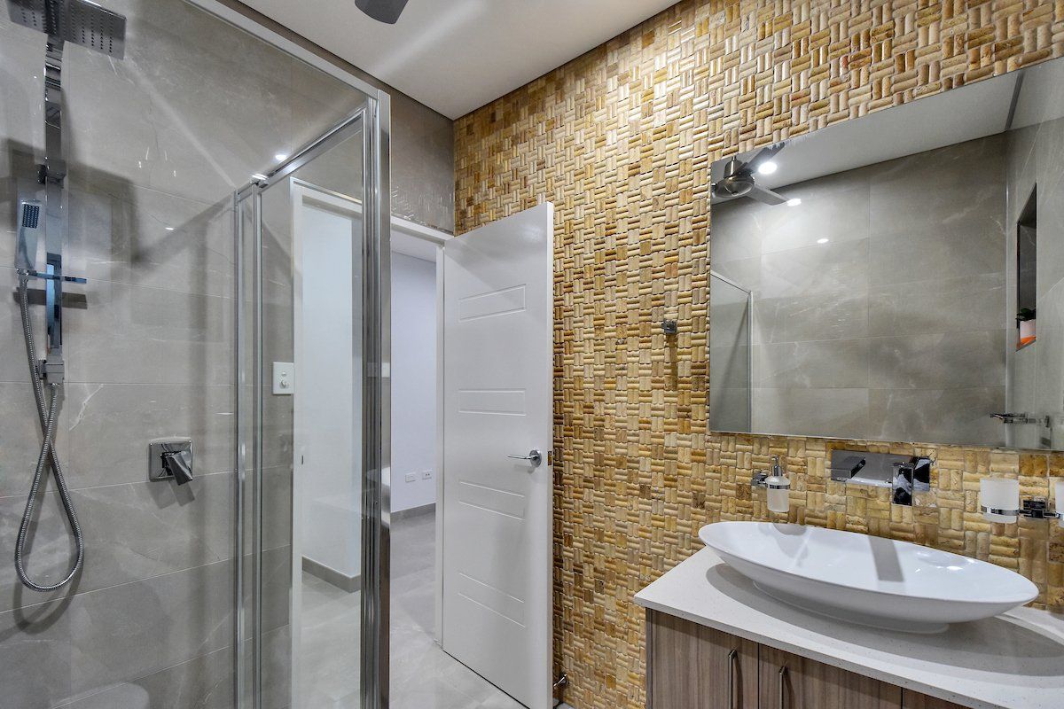 A bathroom with a sink , toilet , shower and mirror.