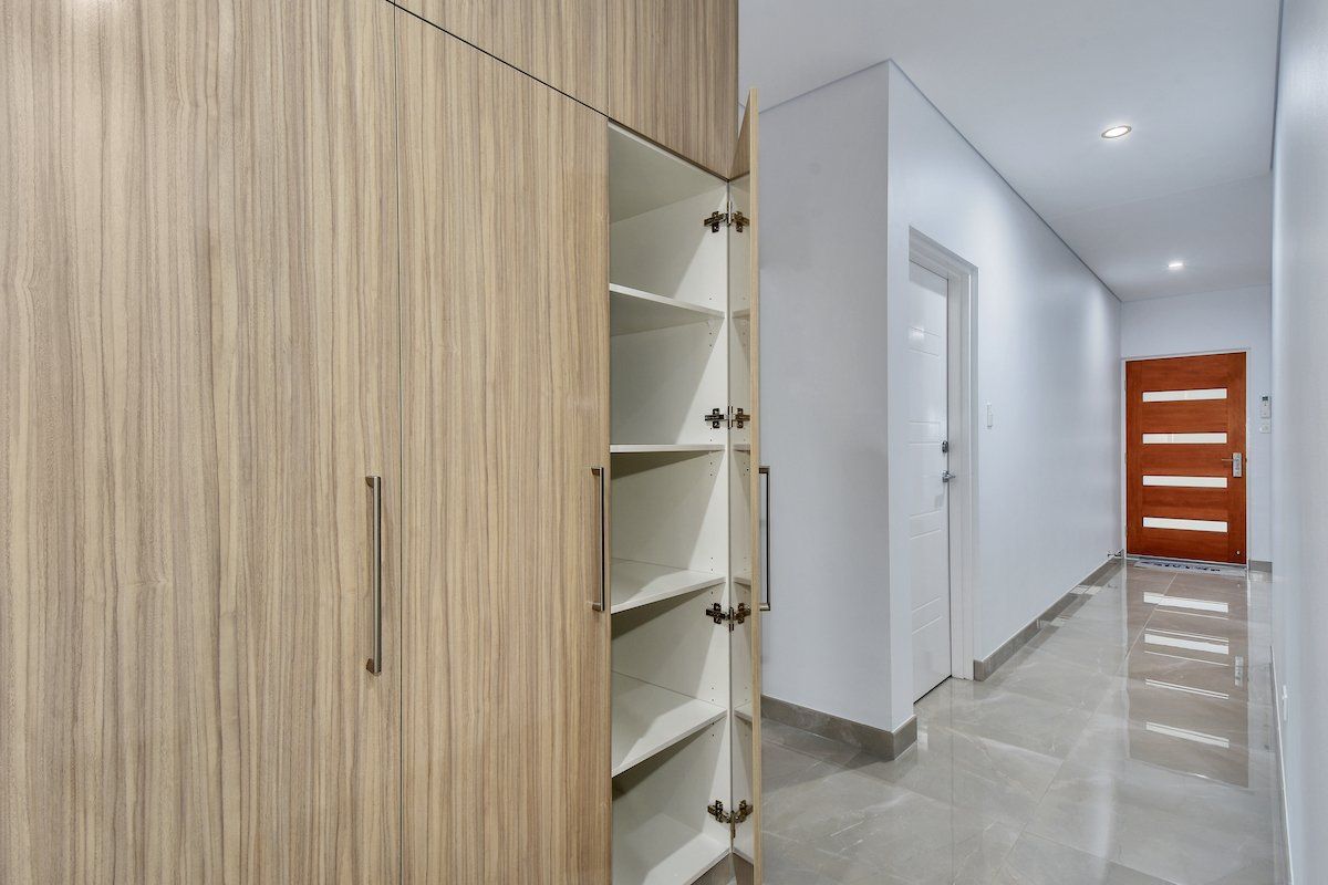 A hallway with wooden cabinets and a red door